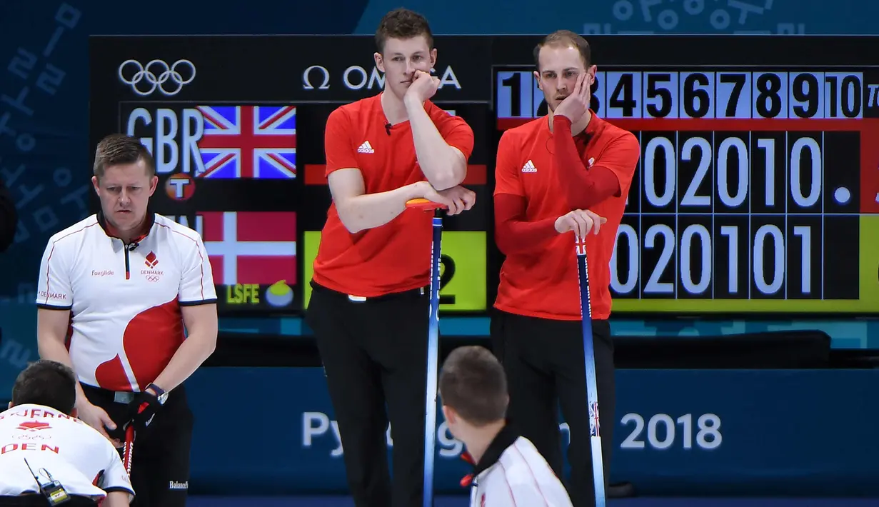 Atlet Curling dari Inggris Thomas Muirhead dan Kyle Smith menunggu giliran saat sesi round robin antara Inggris dan Denmark selama Olimpiade Musim Dingin Pyeongchang 2018 di Gangneung Curling Centre di Gangneung (19/2). (AFP Photo/Wang Zhao)