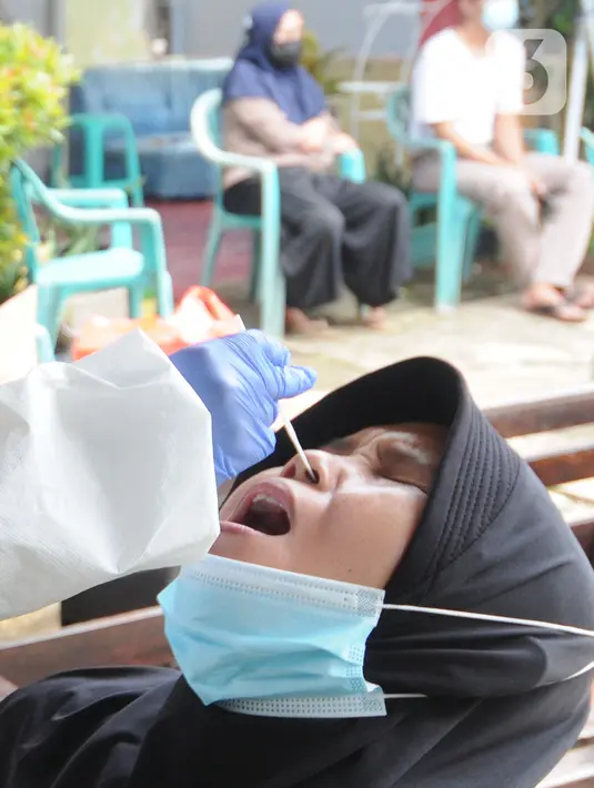 Petugas Puskesmas mendatangi warga di kawasan permukiman RT 04/ RW 02 Kelurahan Srengseng Sawah, Jagakarsa, Jakarta, Selasa (25/05/2021).  Satu RT di wilayah itu menerapkan lockdown skala mikro setelah 13 warga dikonfirmasi positif Covid-19. (merdeka.com/Arie Basuki)