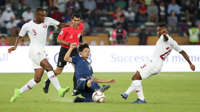 Bek Qatar, Assim Madibo, berebut bola dengan gelandang Jepang, Gaku Shibasaki, pada laga final Piala Asia 2019. (AFP/Karim Sahib)
