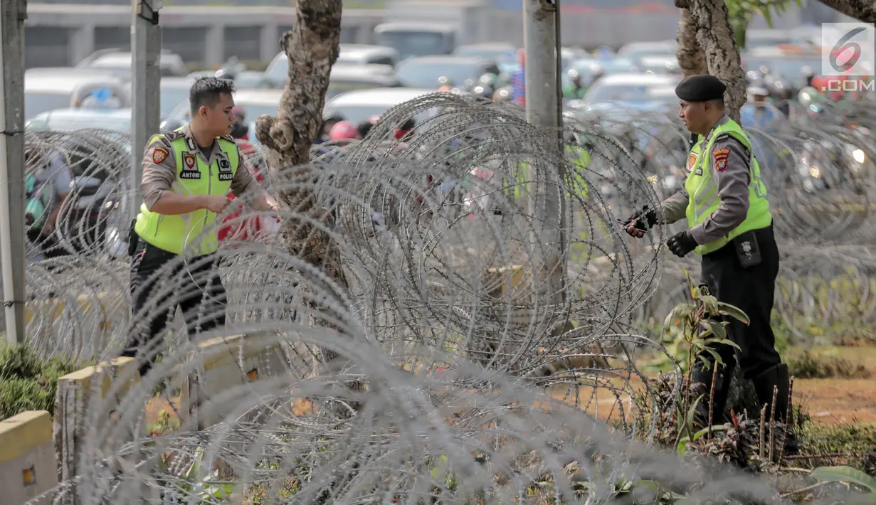 Pihak kepolisian memasang kawat berduri jelang unjuk rasa yang akan digelar mahasiswa di depan gedung DPR/MPR, Jakarta, Selasa (24/9/2019). Sedikitnya 18.000 personel gabungan diturunkan untuk mengamankan jalannya unjuk rasa mahasiswa dan masyarakat di depan Gedung DPR. (Liputan6.com/Faizal Fanani)