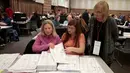 Petugas meneliti kembali surat suara pemilihan Presiden AS di Waterford Township, Michigan, Amerika Serikat (5/12). Menurut komisi pemilihan Wisconsin, batas waktu penghitungan ulang adalah 13 Desember. (Reuters/Rebecca Cook)