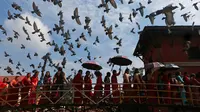 Kumpulan wanita Hindu Nepal berbaris memasuki kuil Pashupatinath untuk melakukan sembahyang saat festival Teej di Kathmandu, Nepal, Kamis (24/8). Festival Teej didedikasikan untuk Dewi Parwati sebagai pasangan Dewa Siwa. (Niranjan Shrestha/AP)