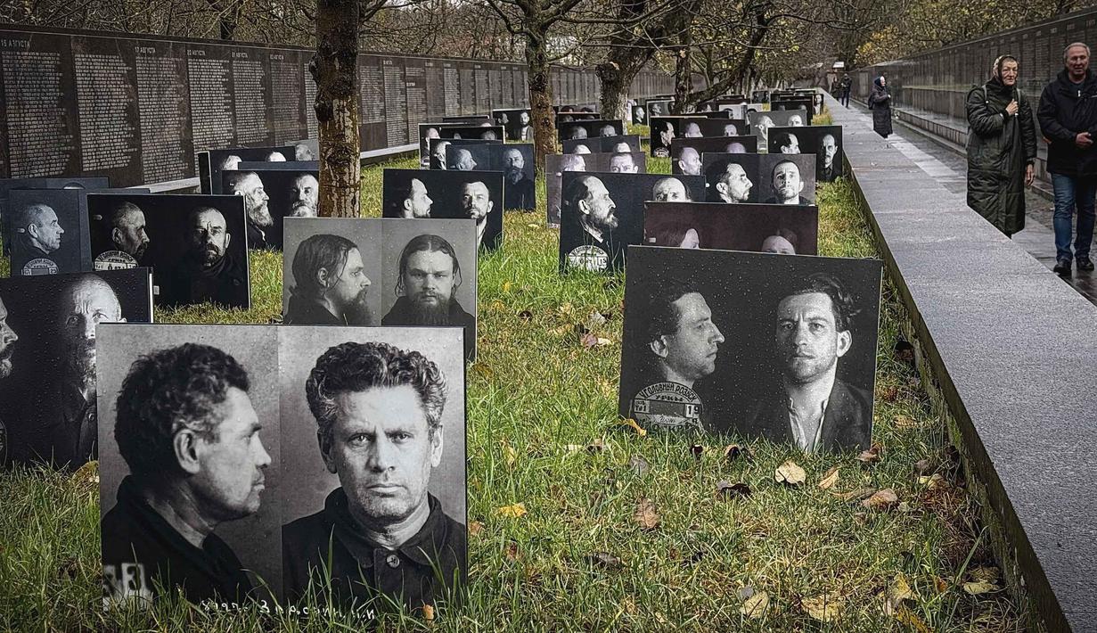 Orang-orang mengunjungi tugu peringatan bagi para korban represi politik di Butovo, di luar Moskow, pada Kamis 30 Oktober 2025, menandai hari peringatan. Setelah jatuhnya Uni Soviet, sejarah kelam ini mulai terungkap. Arsip yang dibuka sebagian dan penyelidikan yang dilakukan memungkinkan identifikasi para korban. (Nikita BORISSOV/AFP)