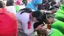 Para orangtua memegang kepala anak mereka saat ritual membasuh kaki ibu di Lembaga Pembinaan Khusus Anak (LPKA) Kelas 1 Tangerang, Banten (17/4). Kegiatan ini dilakukan serentak di seluruh LPKA di Indonesia. (Merdeka.com/Arie Basuki)