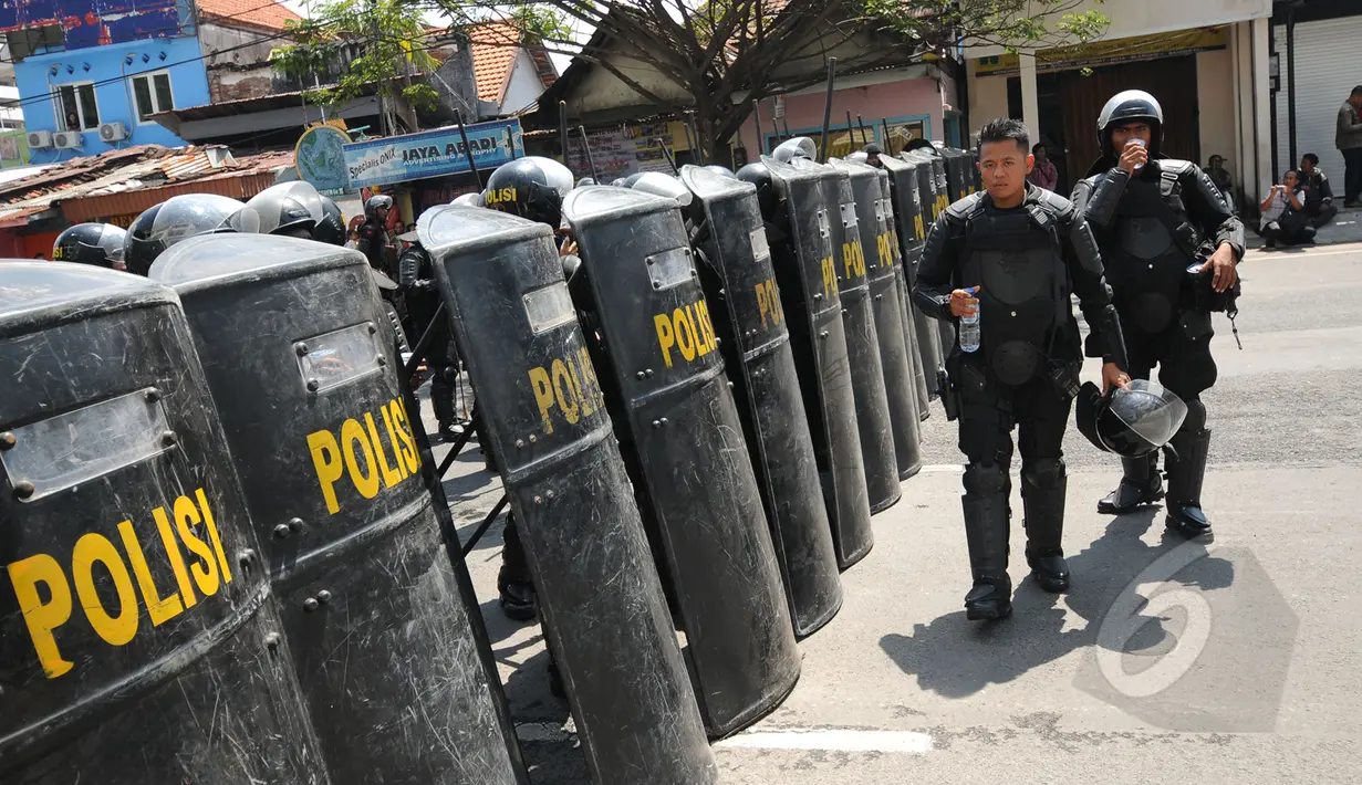 Puluhan anggota Brimob Polda Jatim membuat barikade penutup jalan Embong Malang, Surabaya, Jawa Timur, Sabtu (18/4/2015). Jalan Embong Malang, Surabaya ditutup total selama aksi unjuk rasa para supporter Persebaya 1927. (Liputan6.com/Helmi Fithriansyah)