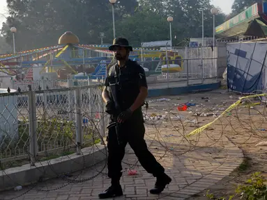 Petugas polisi Pakistan berjaga di lokasi bom bunuh diri di taman Gulshan e Iqbal Park di Lahore, Pakistan, Senin (28/3). Korban tewas akibat ledakan bom tersebut mencapai sekitar 69 orang. (AFP/ARIF ALI)