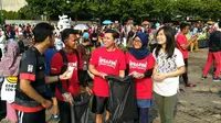Sekitar seratus orang peserta iradio sapu bersih, kompak memakai baju merah, dan memunguti sampah