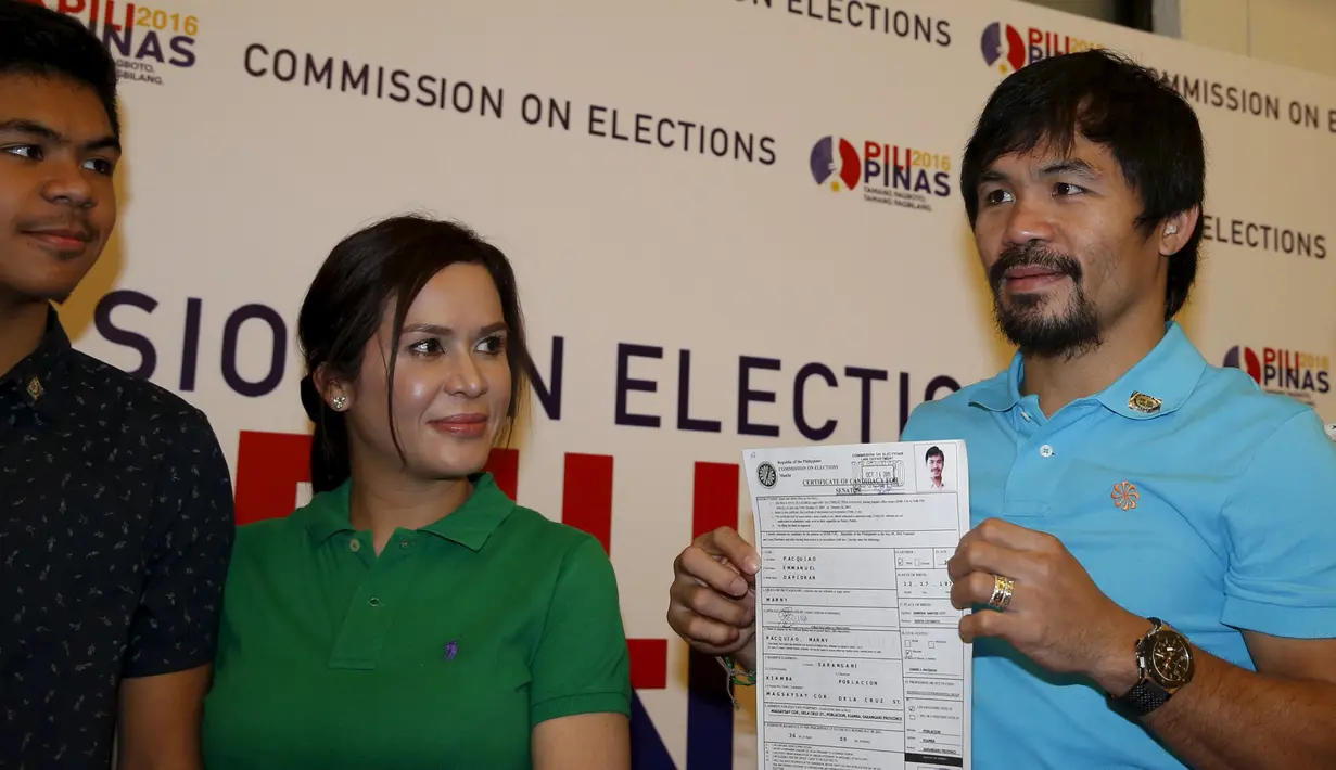 Manny Pacquiao (kanan) menunjukkan Sertifikat Pencalonan Senator  kepada awak media di Mei 2016 pemilihan nasional, di Komisi Pemilihan Umum, Manila, Filipina (16/10/2015). Pacquiao ditemani istrinya Jinkee dan anaknya Michael. (REUTERS/Erik De Castro)