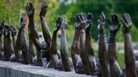 Patung perunggu yang berjudul "Raise Up" dipajang dalam pameran National Memorial for Peace and Justice, Montgomery, AS (23/4). (AP Photo / Brynn Anderson)