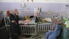 Amira Al-Jojo (kiri) berdiri di samping putranya yang berusia 10 bulan, Yousef Al-Jojo, yang menderita kekurangan gizi di Rumah Sakit Martir Al-Aqsa, tempat ia menjalani perawatan, di Deir al-Balah di Jalur Gaza tengah pada Sabtu, 1 Juni 2024. (AP Photo/ Jehad Alshrafi)