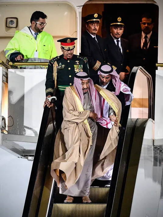 Raja Arab Saudi, Salman bin Abdulaziz Al Saud menuruni tangga eskalator saat tiba di Vnukovo International Airport, Rusia, 4 Oktober 2017. Eskalator emas itu mendadak macet dan membuat raja serta sejumlah pendampingnya  kebingungan (Alexander NEMENOV/AFP)