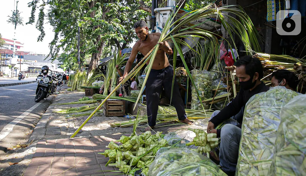 Pedagang membuat cangkang ketupat di kawasan Palmerah, Jakarta, Minggu (18/7/2021). Pemberlakuan PPKM Darurat membuat penjualan cangkang ketupat jelang Idul Adha tahun ini sepi pembeli. (Liputan6.com/Faizal Fanani)