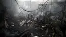 Petugas damkar memadamkan bara api yang masih tersisa di puing salah toko kembang api di wilayah Bocaue, 30 km dari Ibu Kota Filipina, Manila, Rabu (12/10). Sebuah kebakaran memicu ledakan dari kembang api yang ada di beberapa toko. (Noel Celis/AFP)