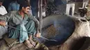 Seorang pedagang Pakistan memanggang kacang pinus di pasar di Lahore (13.12). Pakistan merupakan salah satu penghasil kacang pinus terbaik di dunia. (AFP Photo/Arif Ali)