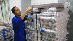 Karyawan memeriksa pasokan uang di Cash Pooling Bank Mandiri, Jakarta, Kamis (9/5/2019). Bank Mandiri menyiapkan uang tunai untuk mengantisipasi kenaikan kebutuhan di masyarakat saat Ramadan dan jelang Idul Fitri 2019. (Liputan6.com/Angga Yuniar)