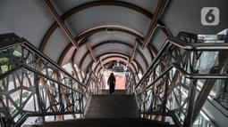 Pejalan kaki menggunakan fasilitas jembatan penyeberangan orang (JPO) di Jalan Kolonel Sugiono, Duren Sawit, Jakarta Timur, Senin (7/2/2022). JPO Kolonel Sugiono yang berada dekat Kanal Banjir Timur itu didesain dengan bentuk yang modern namun sarat kearifan lokal. (merdeka.com/Iqbal S Nugroho)