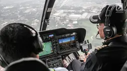 Pilot saat menerbangkan Helikopter jenis Bell 505 di Bandara khusus Wiladatika, Cibubur, Jakarta, Senin (3/6). Heli City melayani 30 penerbangan mudik ke berbagai daerah di Jawa Barat dengan durasi penerbangan 40 menit. (Liputan6.com/Faizal Fanani)