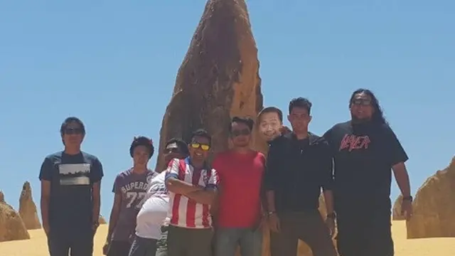 pria bawa foto sahabat ketika berlibur