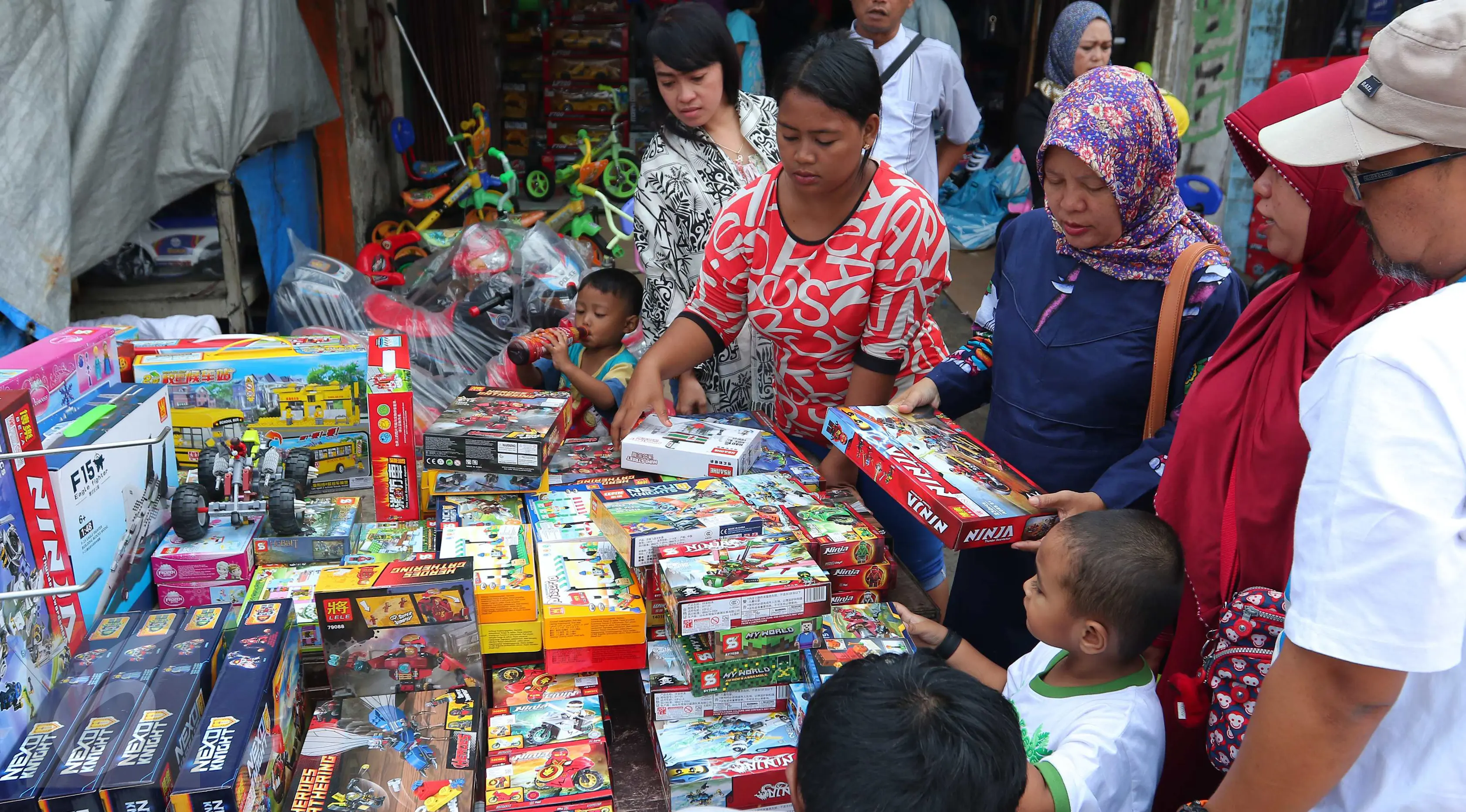 Sejumlah pembeli memilih mainan anak yang dijual di Pasar Gembrong, Jakarta, Jumat (8/7). Libur lebaran banyak dimanfaatkan orang tua untuk mengajak anaknya berbelanja aneka mainan murah. (/Angga Yuniar)