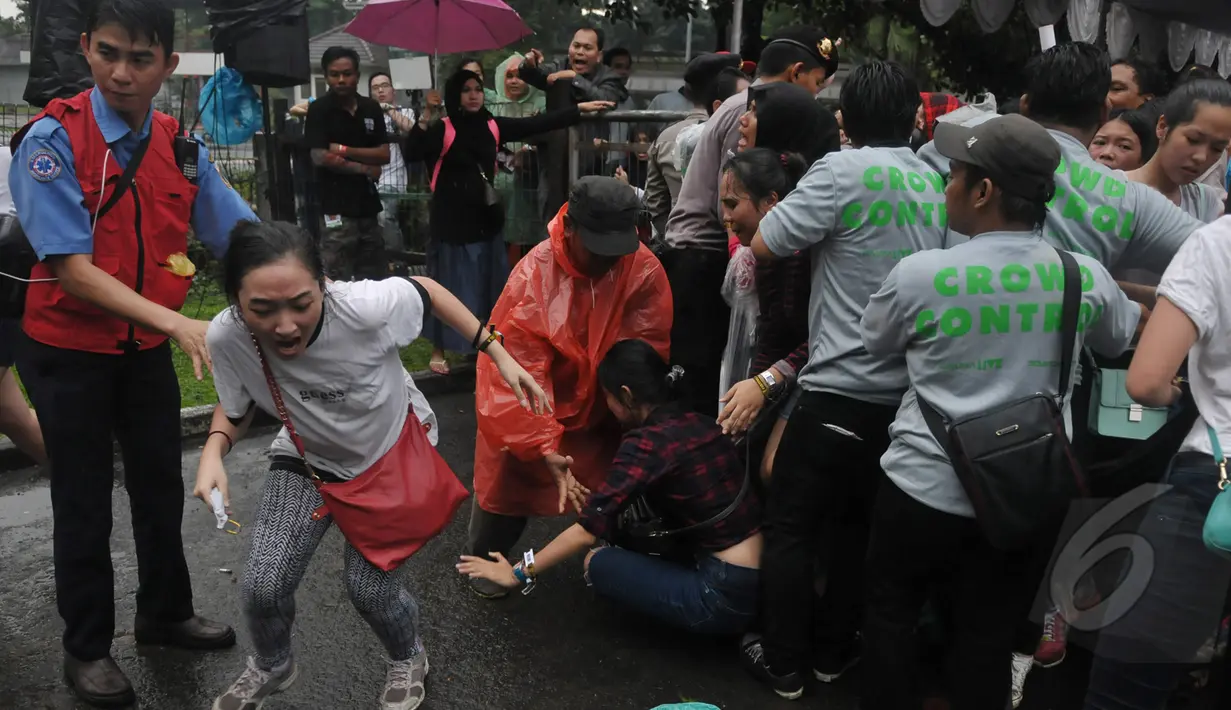 Sejumlah fans diamankan petugas karena limbung saat saat mengantre untuk menonton konser One Direction, Senayan, Jakarta, Rabu (25/3/2015). Puluhan ribu orang rela mengantre untuk melihat konser One Direction. (Liputan6.com/Johan Tallo)