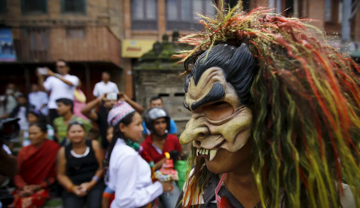 Peserta mengunakan topeng saat festival cahaya atau disebut festival Neku Jatra-Mataya di Lalitpur, Nepal (31/8/2015). Umat Buddha Nepal memperingati hari kemenangan Buddha Sakyamuni terhadap mahluk bernama Mara. (REUTERS/Navesh Chitrakar)