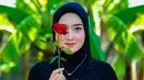 Potret penyanyi asal Blora itu tampil dengan hijab sambil memegang bunga. Penampilannya cantik menawan saat berhijab. [Instagram/yeniinka]