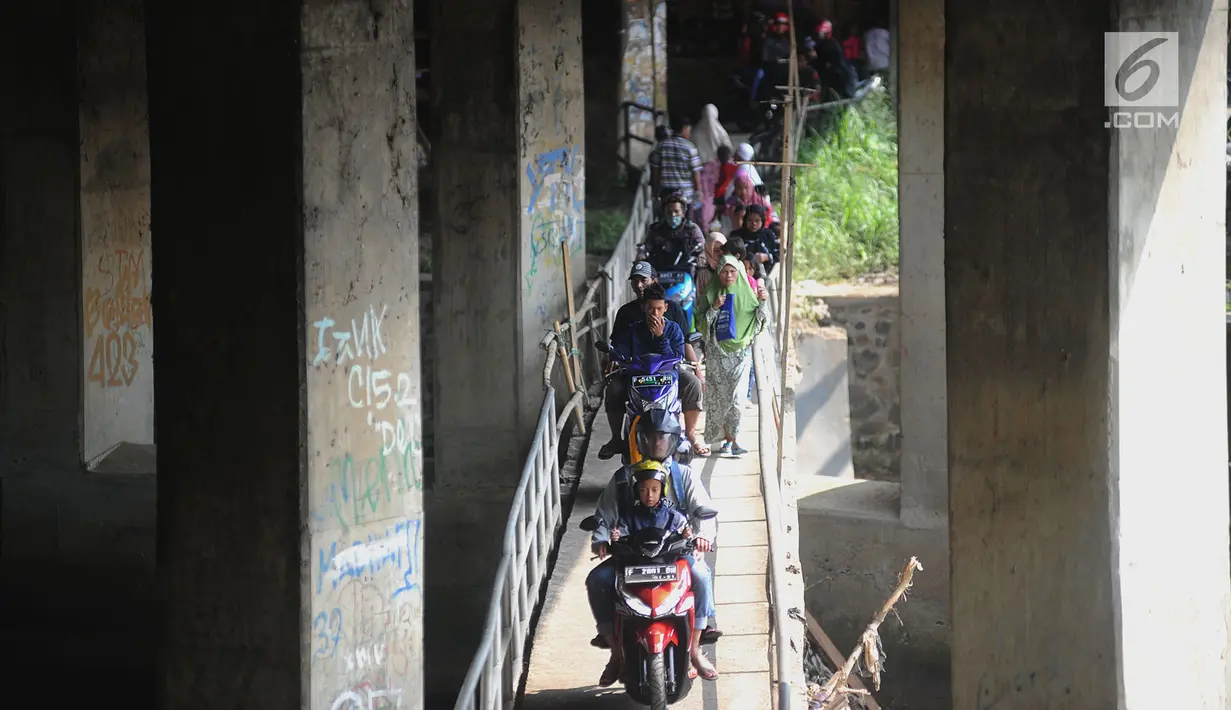 Pengendara motor melewati jembatan Ciliwung yang berada di bawah tol ruas Gadog, Ciawi, Bogor (16/68). Jembatan ini menjadi jalan alternatif bagi pemotor dari kawasan Bogor menuju arah Puncak dan Sukabumi. (Merdeka.com/Arie Basuki)