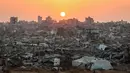 Farhan Haq menambahkan, layanan kemanusiaan di Gaza masih berada di bawah tekanan berat akibat pengungsian massal, kerusakan infrastruktur, dan situasi keamanan yang tidak stabil, terutama di wilayah utara. Tampak dalam foto, matahari terbenam di atas kawasan Jabalia yang rusak parah di bagian utara Jalur Gaza pada Jumat 7 November 2025. (Omar AL-QATTAA/AFP)