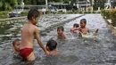 Anak-anak berenang di kolam air mancur penghias kawasan Pasar Baru, Jakarta, Selasa (29/1). Keterbatasan lahan bermain menyebabkan sebagian anak di Ibukota bermain tidak pada tempatnya, meskipun berbahaya bagi keselematan. (Liputan6.com/Immanuel Antonius)