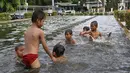 Anak-anak berenang di kolam air mancur penghias kawasan Pasar Baru, Jakarta, Selasa (29/1). Keterbatasan lahan bermain menyebabkan sebagian anak di Ibukota bermain tidak pada tempatnya, meskipun berbahaya bagi keselematan. (Liputan6.com/Immanuel Antonius)