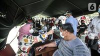 Petugas mengukur suhu warga penerima vaksin Covid-19 saat program Vaksinasi Keliling di RPTRA Pulo Besar, Jakarta, Senin (12/7/2021). Pemprov DKI menggelar Vaksinasi Keliling dengan sistem jemput bola guna mempermudah pelayanan kepada masyarakat di area padat penduduk. (merdeka.com/Iqbal S Nugroho)