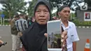 Pihak keluarga menunjukan WNI yang dievakuasi dari Wuhan, China saat menunggu di Bandara Halim Perdana Kusuma, Jakarta, Sabtu (15/2/2020). Pemerintah secara resmi memulangkan 238 WNI ke daerah masing-masing seusai menjalani observasi selama 14 hari di Ranai, Natuna. (Liputan6.com/Herman Zakharia)