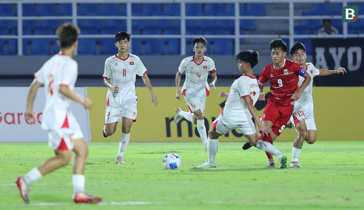 Pemain Timnas Indonesia U1-7, Mochamad Mierza Firjatullah menggiring bola melewati sejumlah pemain Vietnam dalam laga Grup A Piala AFF U-17 2026 di Stadion Gelora Delta Sidoarjo, Sidoarjo, Jawa Timur, Minggu (19/04/2026). (Bola.com/M Iqbal Ichsan)
