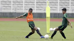 Pemain Timnas Indonesia U-22, Dallen Doke, berebut bola dengan Firza Andika, saat latihan di Stadion Madya, Senin (21/1). Pemain yang pernah merumput di Spanyol ini bertekad menembus skuat utama untuk tampil di Piala AFF U-22. (Bola.com/M Iqbal Ichsan)