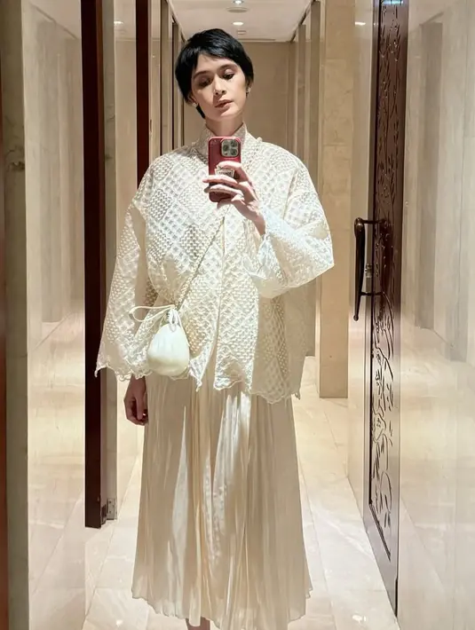 Renata mengenakan atasan lengan panjang putih bertekstur dari desainer Didiet Maulana. Dipadukan rok panjang pleated warna senada dengan tasnya. [@renata711]