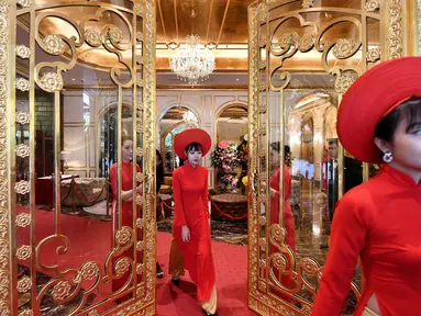 Pegawai bersiap untuk menyambut para tamu di lobi hotel Dolce Hanoi Golden Lake yang baru saja diresmikan di Hanoi, Vietnam pada Kamis (2/7/2020). Hotel tersebut merupakan hotel berlapiskan emas 24 karat pertama di dunia. (Manan VATSYAYANA / AFP)