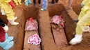 Peti jenazah korban banjir dan tanah longsor saat dimakamkan di sebuah pemakaman di Sierra Leone, Freetown, (17/8). Pemerintah setempat telah mengubur 350 orang yang tewas akibat musibah tersebut. (AP Photo/Manika Kamara)
