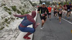 Seorang pria mengenakan kostum superhero Spiderman menggoda para atlet lari di kota tua, Yerusalem, Israel, (18/2).  Sejumlah orang mengikuti lomba lari Maraton Internasional  yang ke-6 di Yerusalem. (REUTERS / Baz Ratner)
