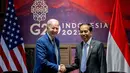 <p>Presiden Joko Widodo bersalaman dengan Presiden Amerika Serikat (AS) Joe Biden saat mengadakan pertemuan bilateral di Nusa Dua, Bali (14/11/2022). Pertemuan digelar menjelang Konferensi Tingkat Tinggi (KTT) G20. (AFP/Saul Loeb)</p>