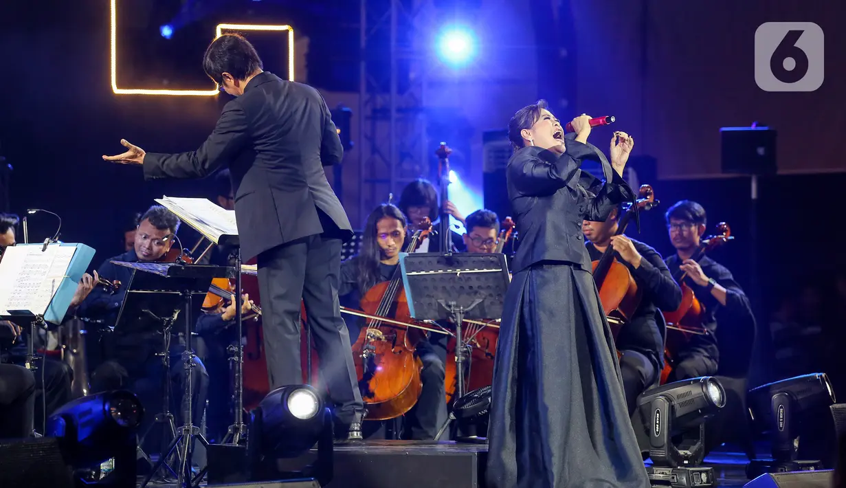 Penyanyi Rita Effendi bersama Twilite Orchestra saat membawakan lagu bertema Symphony Under the Stars: Movie Fest II di Lippo Mall Kemang, Jakarta, Sabtu (26/10/2019). 13 Soundtrack film Indonesia maupun mancanegara disajikan dalam outdoor orchestra concert. (Liputan6.com/Fery Pradolo)