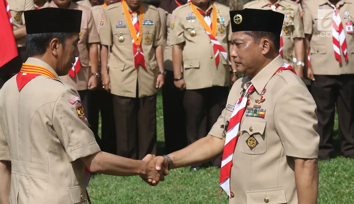 Presiden Joko Widodo (Jokowi) berjabat tangan dengan Komjen Pol (Purn) Budi Waseso saat pelantikan Ketua Kwartir Nasional Gerakan Pramuka masa bakti 2018-2023 di halaman Istana Merdeka, Jakarta, Kamis (27/12). (Liputan6.com/Angga Yuniar)