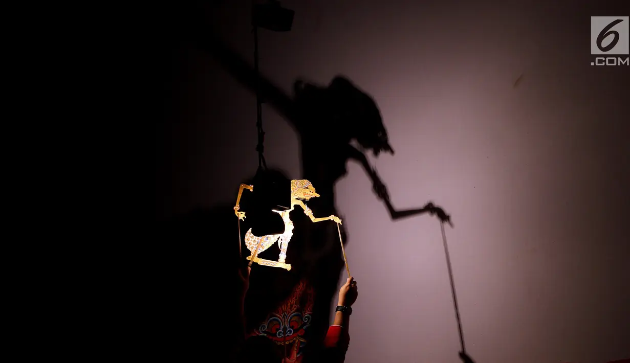 Dalang Ki Anom Dwijo Kangko memainkan pertunjukan wayang kulit lakon "Bima Jumeneng Guru Bangsa" di Tugu Proklamasi, Jakarta, Sabtu (27/1). Pagelaran wayang kulit dalam rangka peringatan HUT PDI Perjuangan ke-45. (Liputan6.com/Johan Tallo)