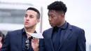 Pemain Bayern Munchen, Thiago dan David Alaba berjalan sebelum keberangkatan di bandara Munich, Jerman (2/4). Munchen akan bertanding melawan wakil Spanyol, Sevilla pada leg pertama perempatfinal Liga Champions. (Sven Hoppe/dpa via AP)