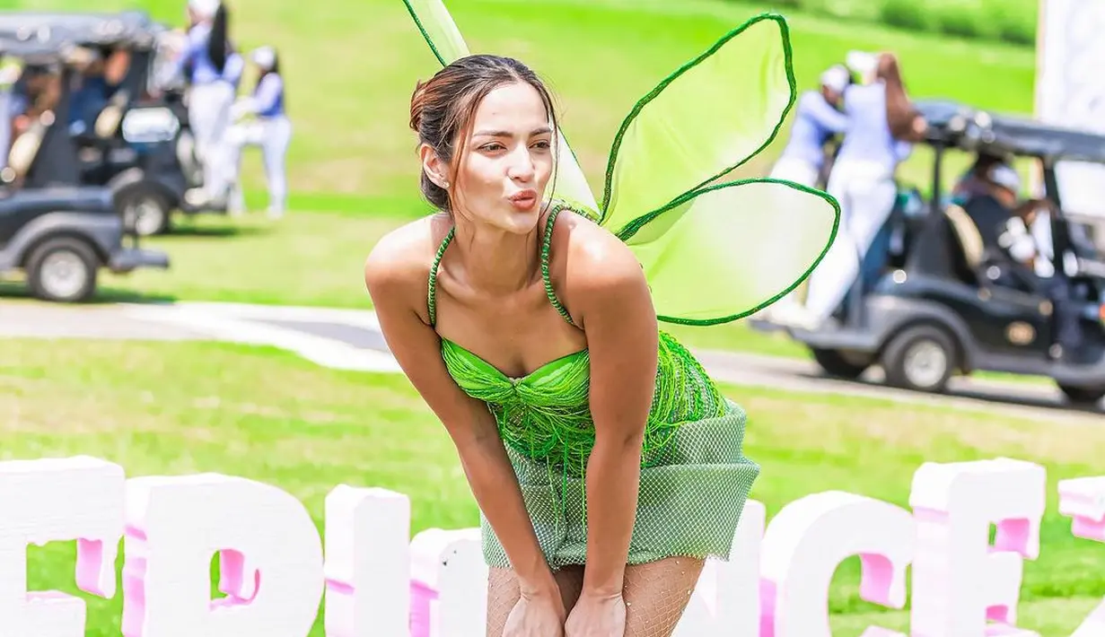 Menjadi tinkerbell, Nia Ramadhani tampil cute dengan kostum serba hitam. Bustier tali lilit berwarna hijau neon dan rok mini bertekstur. Dipadukan dengan stocking berjaring dan sayap warna hijau. [@ramadhaniabakrie]