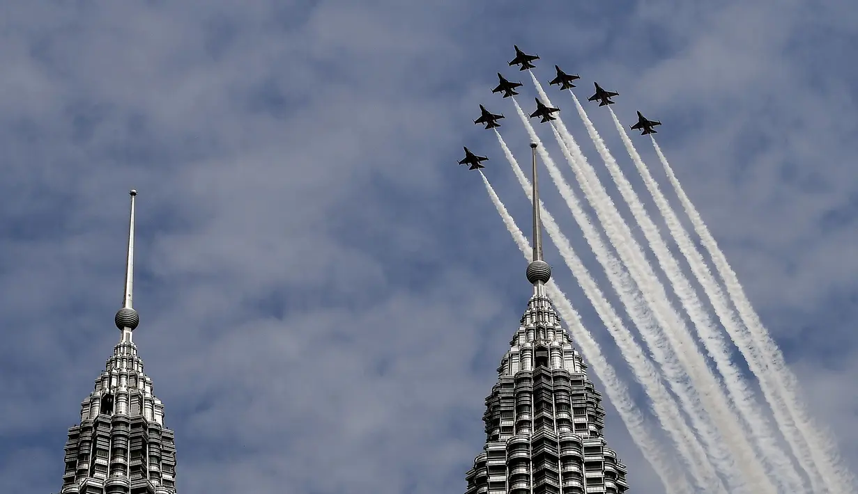 Tim Aerobatik angkatan udara Korea Selatan "Black Eagles" melintasi  menara kembar Petronas dalam Pameran Maritim dan Dirgantara Langkawi Internasional (LIMA) di Kuala Lumpur, Malaysia (29/3). (AFP Photo / Manan Vatsyayana)