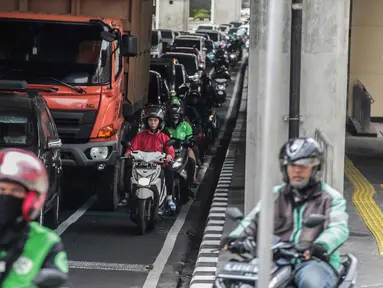 Sejumlah kendaraan roda dua melintas di jalur sepeda di Cipete Raya, Jakarta, Jumat (22/11/2019). Walaupun kendaraan yang melewati jalur sepeda akan dikenai sanksi denda Rp500.000, masih banyak pengendara yang masih bandel melintas dikarenakan kepadatan arus lalu lintas. (Liputan6.com/Faizal Fanani)