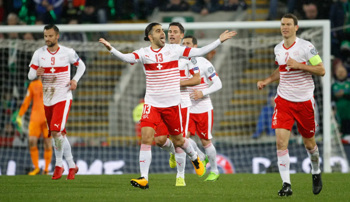 Pemain swiss, Ricardo Rodriguez (tengah) merayakan gol lewat penalti ke gawang Irlandia Utara dalam leg pertama playoff Piala Dunia 2018  di Windsor Park, Jumat (10/11). Bermain di kandang lawan, Swiss meraih kemenangan tipis 1-0. (AP/Peter Morrison)