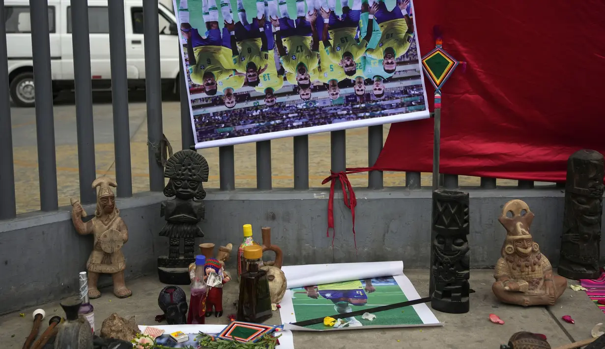 Mengenakan jubah warna-warni, sekelompok dukun Peru mengikat poster Neymar dkk di luar Stadion Nasional di kota Lima. (AP Photo/Martin Mejia)