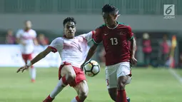 Gelandang Indonesia U-23, Febri Hariyadi (kanan) berebut bola dengan pemain Bahrain pada laga PSSI Anniversary 2018 di Stadion Pakansari, Kab Bogor, Jumat (27/4). Babak pertama Indonesia tertinggal 0-1. (Liputan6.com/Helmi Fithriansyah)