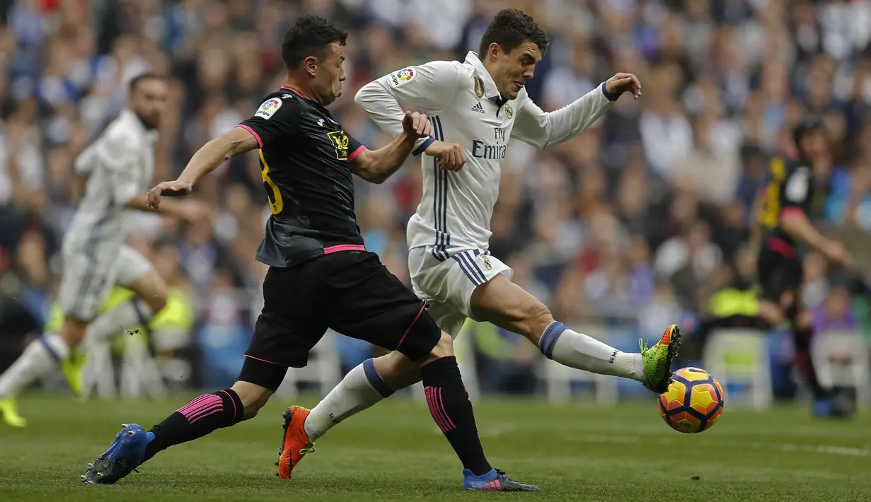 Pemain Real Madrid,  Mateo Kovacic (kanan) menghalau bola dari kejaran pemain Espanyol, Salvador Sevilla pada lanjutan La Liga di Santiago Bernabeu stadium. Madrid, (18/2/2017). Real Madrid menang 2-0. (AP/Francisco Seco)